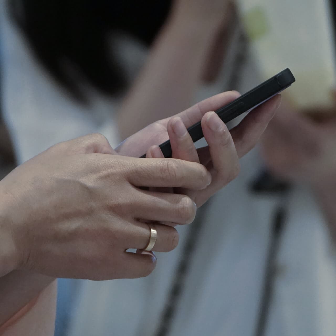 Hands holding a smartphone, the screen turned away from the camera