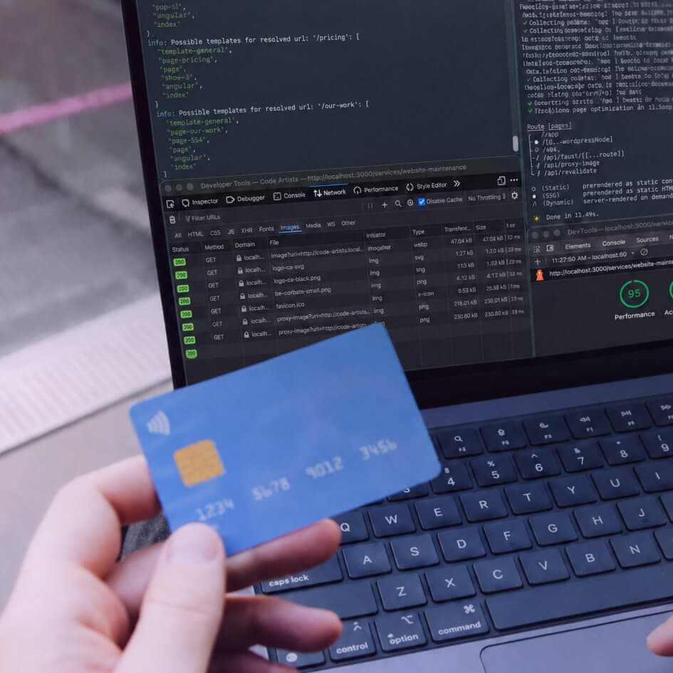 Developer testing a website on a laptop while holding a credit card, with browser developer tools, network requests and performance scores visible on screen